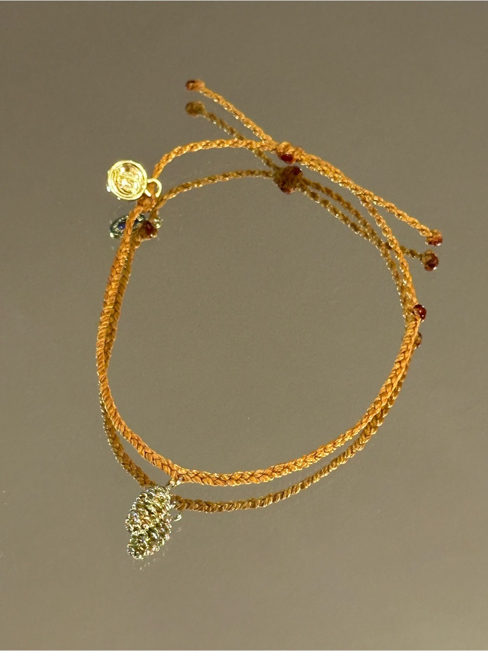 Pura Vida. Burnt Orange Braided Bracelet with Gold Pine Cone Charm